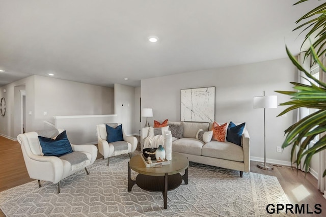 living room with wood finished floors, baseboards, and recessed lighting