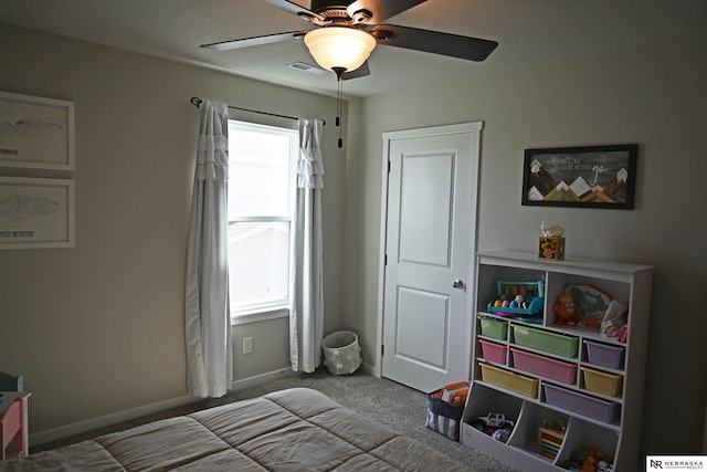 carpeted bedroom with visible vents, baseboards, and ceiling fan