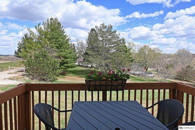 wooden terrace featuring a yard and outdoor dining area