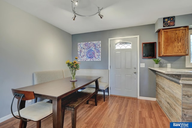dining room featuring light wood-type flooring and baseboards
