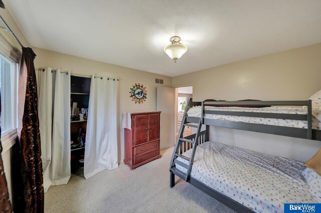 bedroom with visible vents and light colored carpet