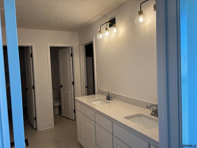5412 N 190th Ave, Elkhorn, NE 68022 - full bathroom featuring tile patterned floors, a textured ceiling, toilet, and double vanity