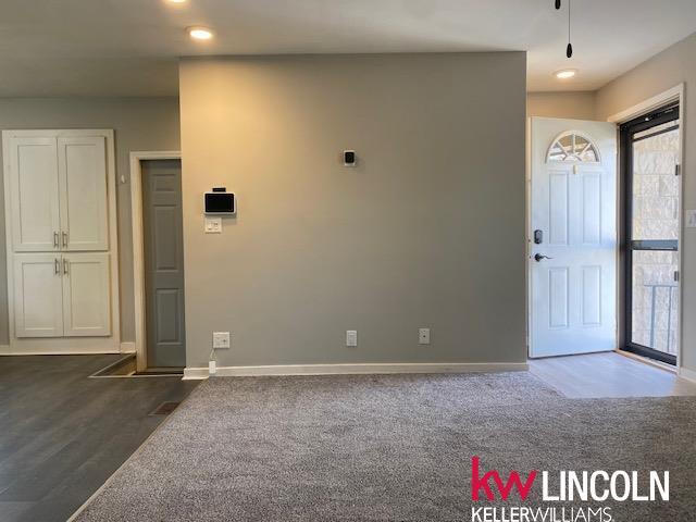 foyer entrance with dark carpet, baseboards, and recessed lighting