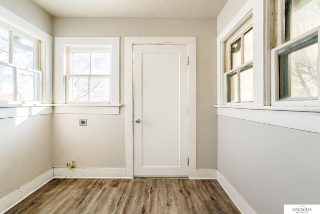 washroom with baseboards, electric dryer hookup, laundry area, and wood finished floors
