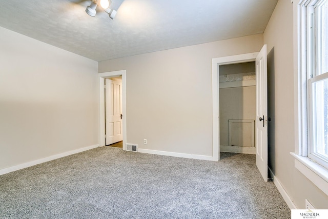 unfurnished bedroom with carpet flooring, baseboards, and visible vents