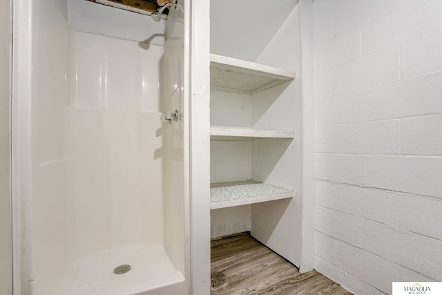bathroom featuring a shower stall and wood finished floors