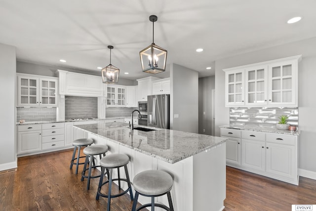 kitchen featuring white cabinets, a sink, backsplash, and appliances with stainless steel finishes