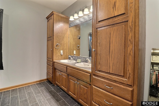 full bath with double vanity, a sink, and baseboards
