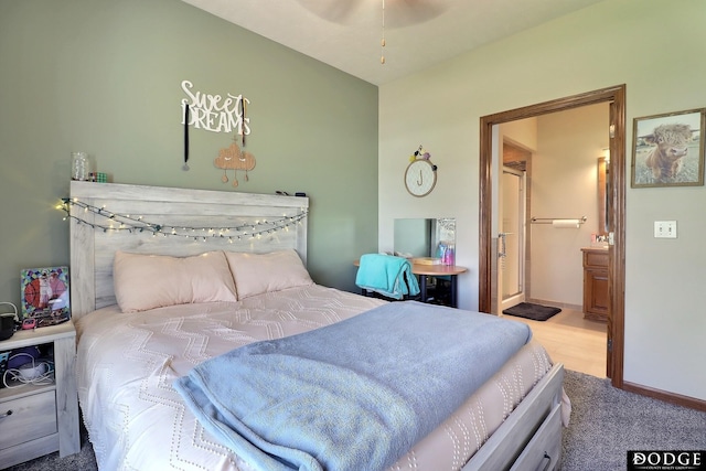 carpeted bedroom featuring ensuite bathroom and baseboards