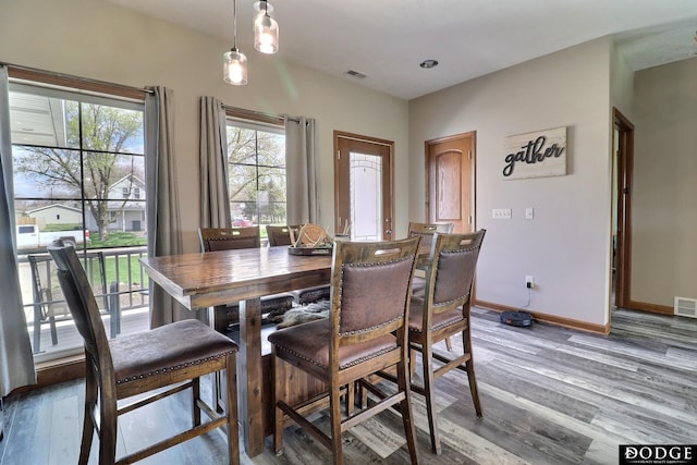 dining room featuring wood finished floors, baseboards, and visible vents