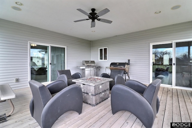 wooden terrace featuring a fire pit, grilling area, and ceiling fan
