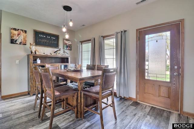 dining area featuring plenty of natural light, light wood-style floors, and baseboards