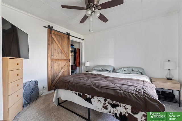 bedroom featuring a barn door, carpet, ornamental molding, and ceiling fan