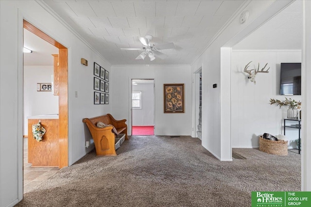 interior space with ornamental molding and a ceiling fan
