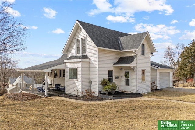 view of side of home with a patio, roof with shingles, driveway, an attached garage, and a lawn