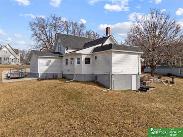 back of house featuring roof with shingles, central AC unit, and a lawn