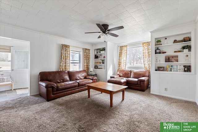carpeted living room featuring built in features and ceiling fan