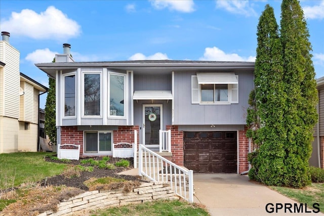 split foyer home with brick siding, an attached garage, and concrete driveway