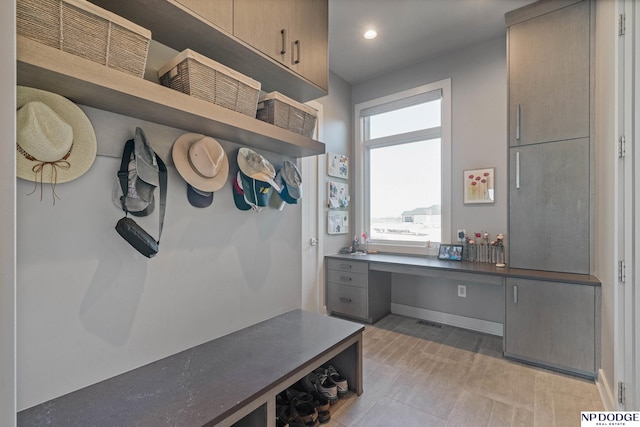 mudroom with baseboards, built in study area, visible vents, and recessed lighting