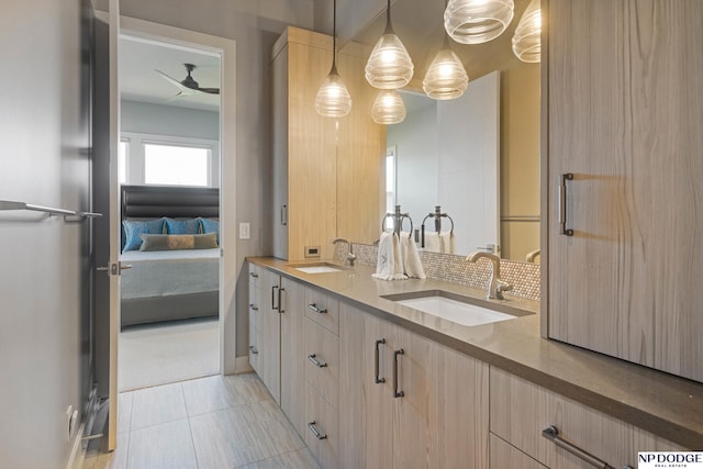 bathroom with double vanity, a sink, a ceiling fan, and connected bathroom