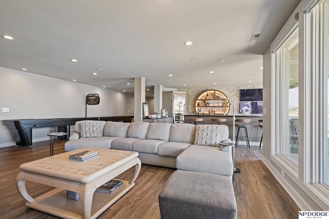 living area featuring visible vents, a wealth of natural light, recessed lighting, and wood finished floors