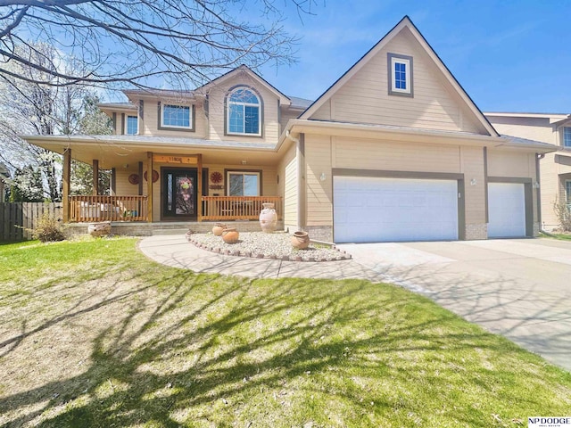 view of front of home with driveway, an attached garage, a front yard, fence, and covered porch
