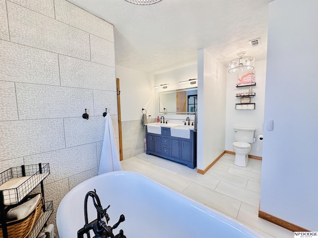 bathroom with a freestanding tub, tile patterned flooring, visible vents, toilet, and double vanity