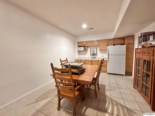 dining area with light tile patterned floors, baseboards, and visible vents