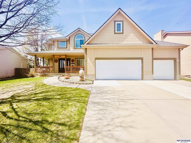 traditional-style home featuring a porch, driveway, an attached garage, and a front lawn