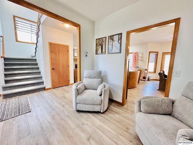 foyer featuring stairs, light wood-style flooring, and baseboards