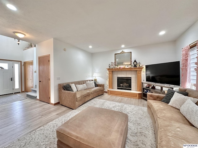 living room with a fireplace, recessed lighting, and light wood-style floors