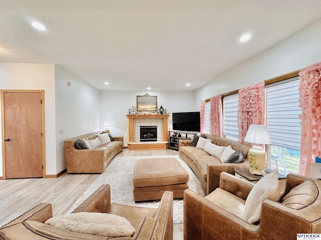 living room with light wood-type flooring, recessed lighting, and a fireplace