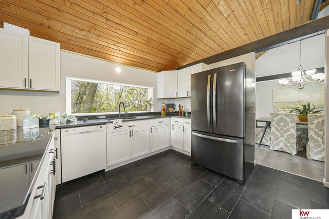 kitchen with freestanding refrigerator, dark countertops, white dishwasher, and wooden ceiling