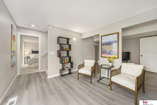 living area featuring recessed lighting, baseboards, visible vents, and light wood-style flooring