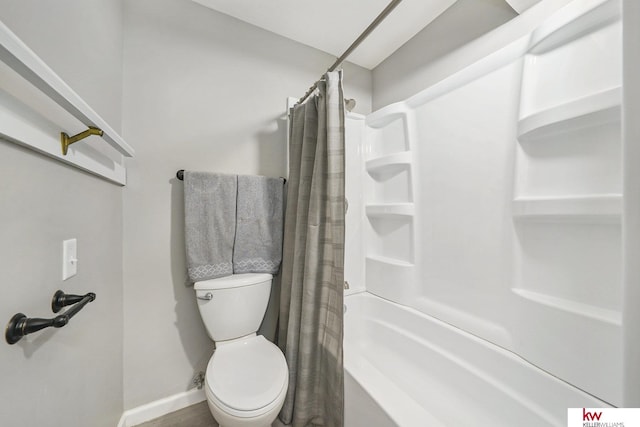 bathroom featuring toilet, baseboards, and shower / bath combination with curtain
