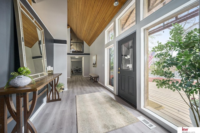 entrance foyer featuring light wood finished floors, high vaulted ceiling, baseboards, wooden ceiling, and visible vents