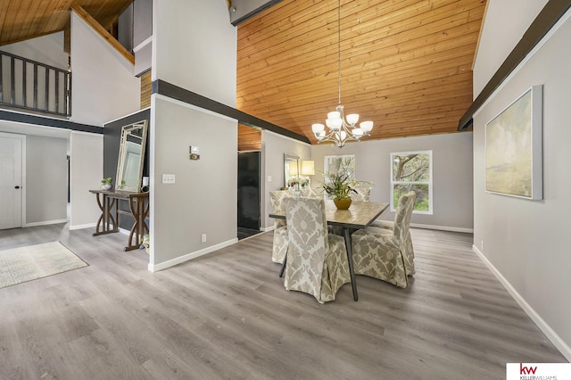 dining space with baseboards, wood ceiling, a notable chandelier, and high vaulted ceiling