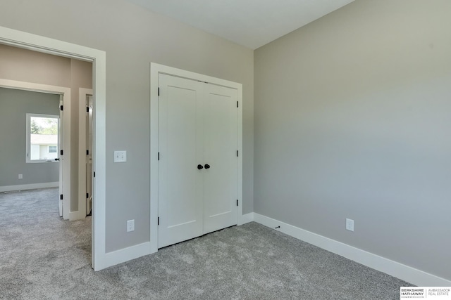 unfurnished bedroom with carpet flooring, baseboards, visible vents, and a closet