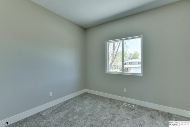 unfurnished room featuring baseboards, visible vents, and carpet