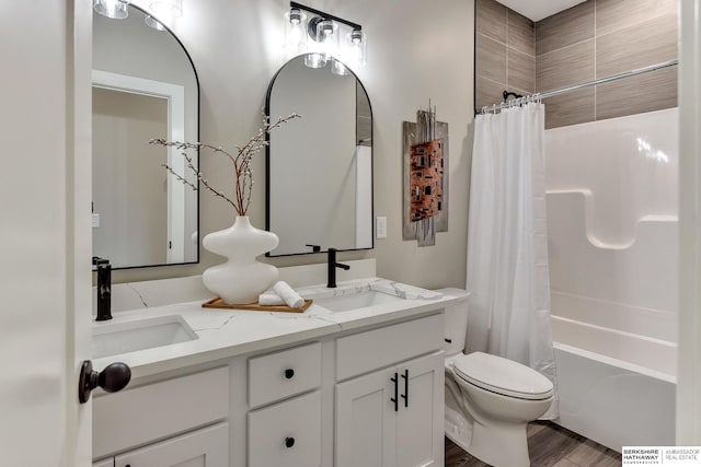 bathroom with a sink, shower / bath combo, toilet, and double vanity