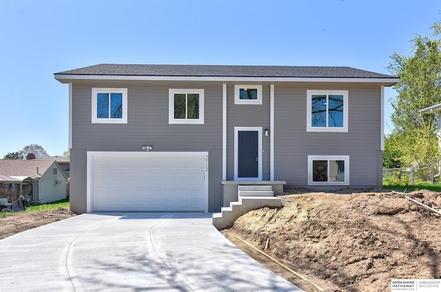 raised ranch featuring a garage and driveway