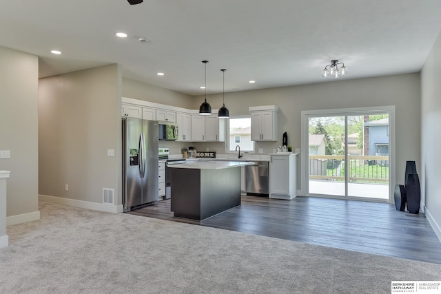 kitchen featuring stainless steel appliances, visible vents, a sink, and dark colored carpet