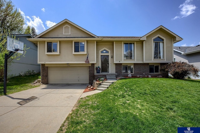 split foyer home featuring a garage, concrete driveway, a front lawn, and brick siding