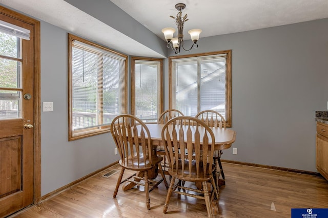dining area featuring an inviting chandelier, baseboards, light wood-type flooring, and visible vents