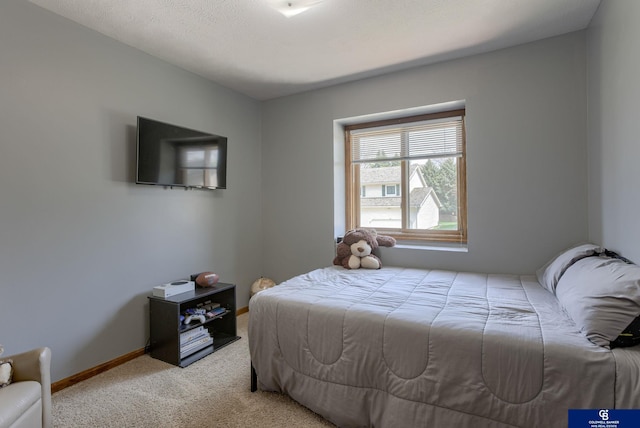 bedroom with baseboards and light carpet
