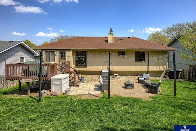 back of property with a chimney, a deck, a patio area, cooling unit, and a yard