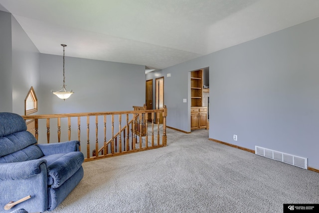 living area featuring light colored carpet, baseboards, an upstairs landing, and visible vents