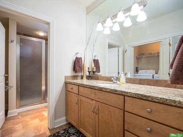 210 S 16th St Unit 901, Omaha, NE 68102 - bathroom featuring washer and dryer, baseboards, a stall shower, and vanity