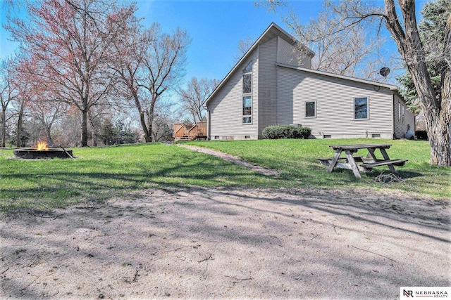 view of side of property with a yard and a fire pit