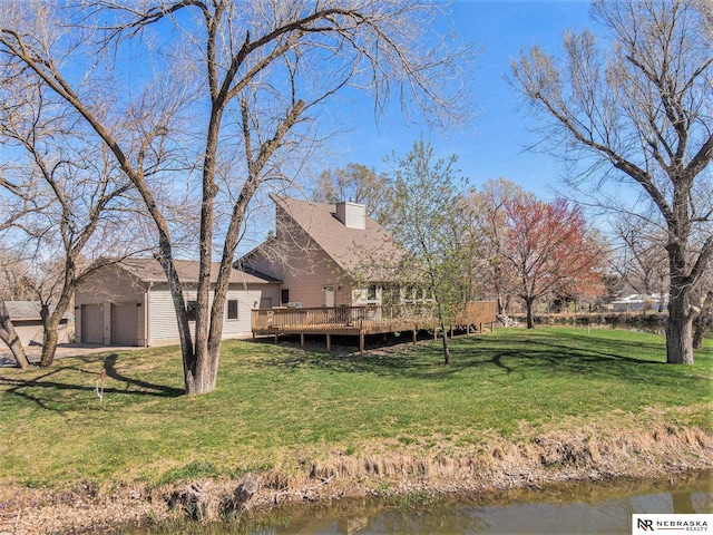 back of property featuring a yard, an outdoor structure, and a deck with water view